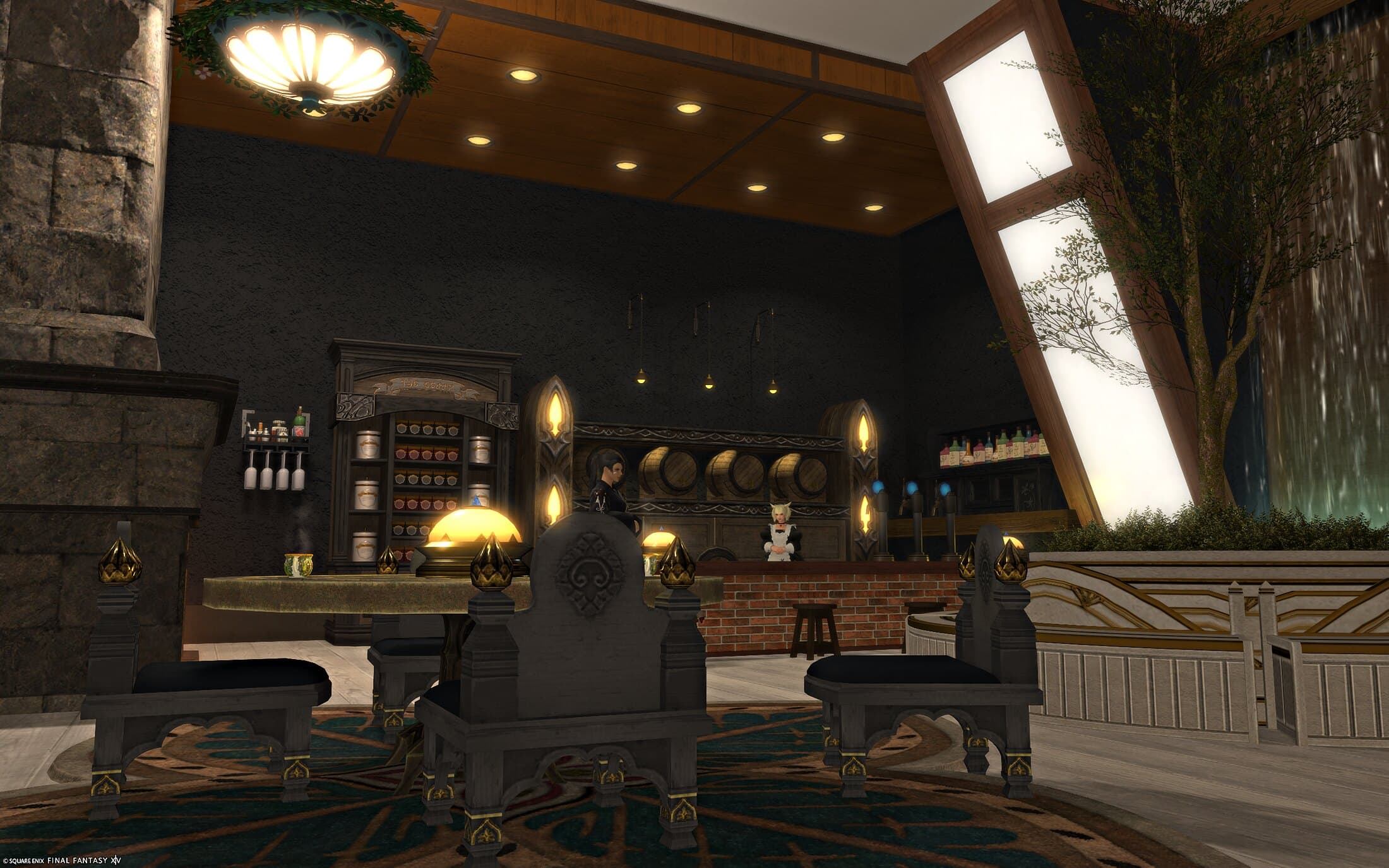 The tavern seen wide, with tall windows, water walls and a stone table setting