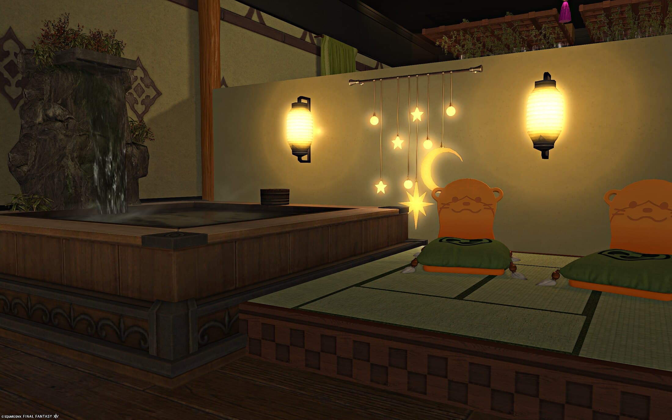 The private bath nook — a bath with its own rock waterfall, a moon and stars ornament glowing on the wall, two paper lanterns and a pair of otter-shaped cushions on the tatami