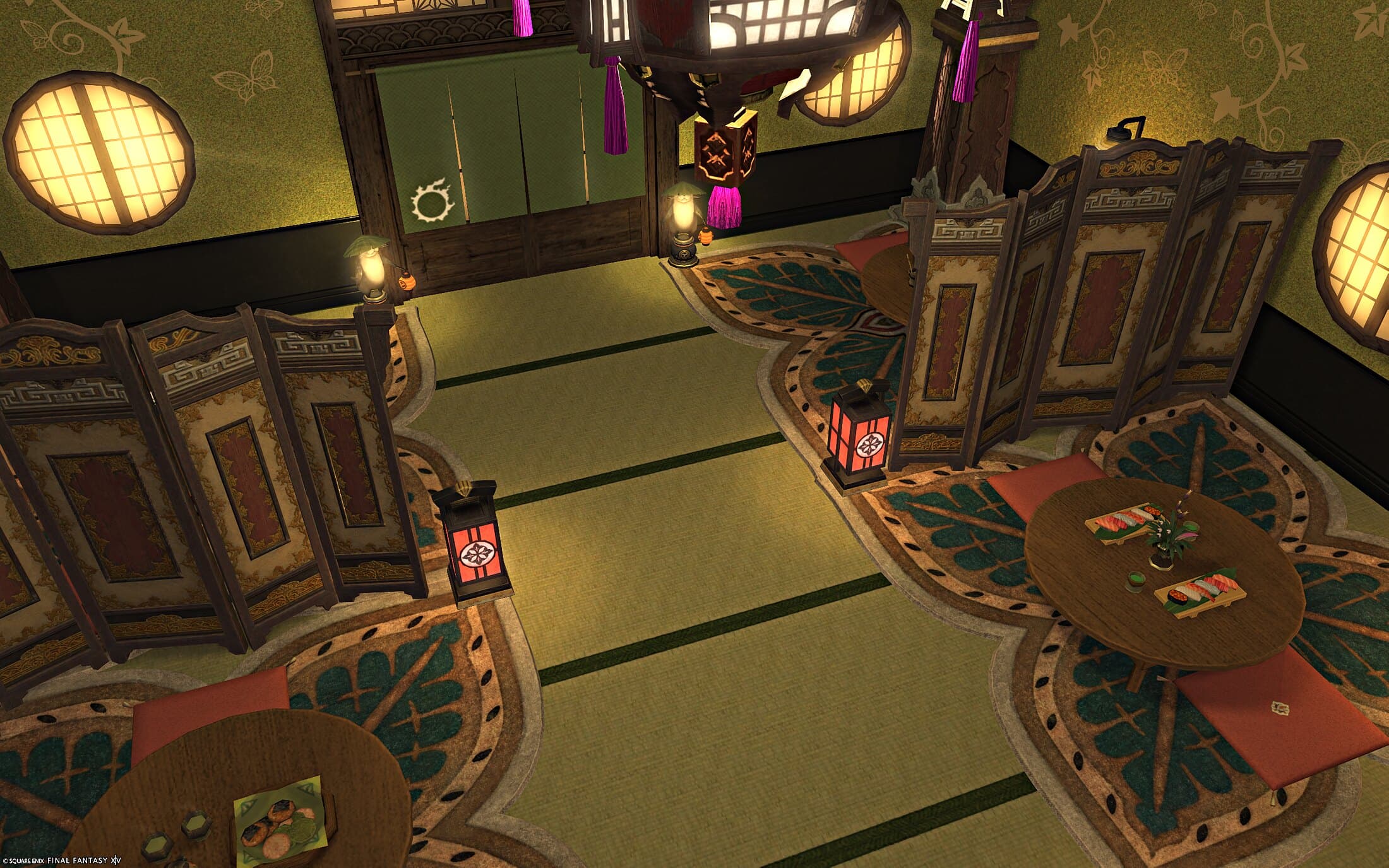 The restaurant from above — round low tables on patterned rugs, folding screens between them, round windows lit along the wall and a tasselled lantern overhead
