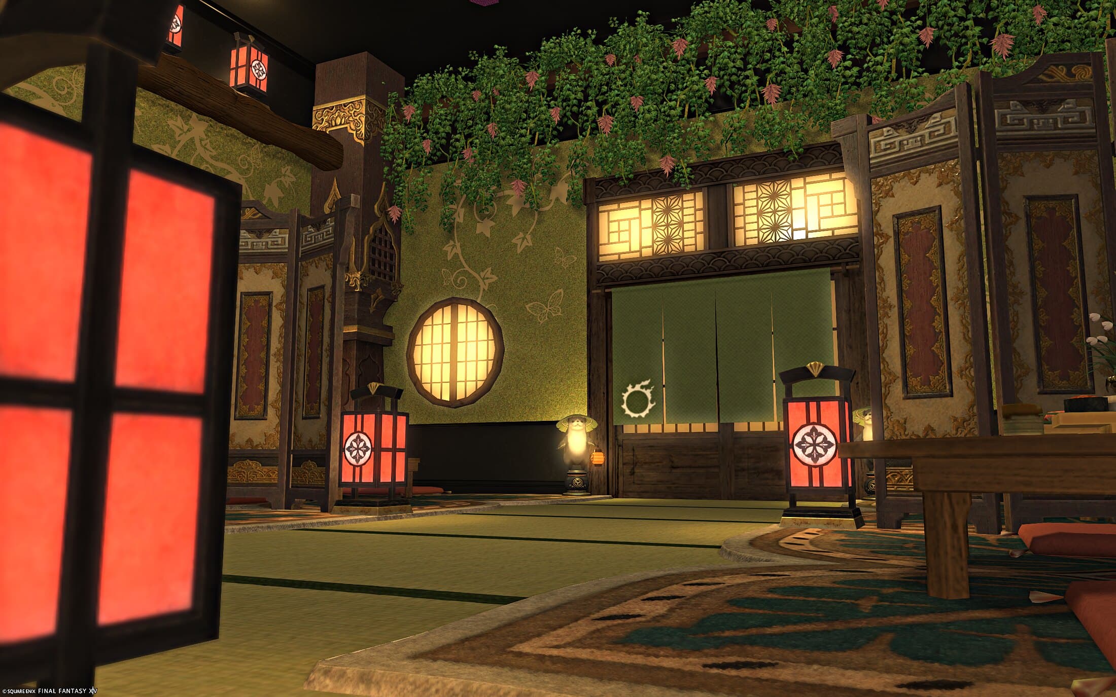 A green doorway under a latticed transom, a round window beside it, hanging vines with pink flowers above and red lanterns either side