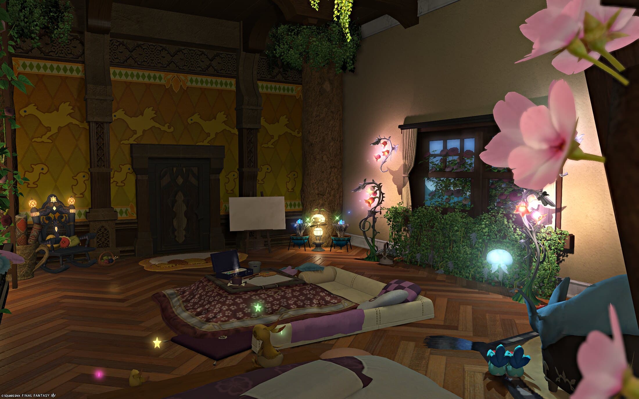 The studio seen past a blossoming branch, floor cushions and low tables beyond