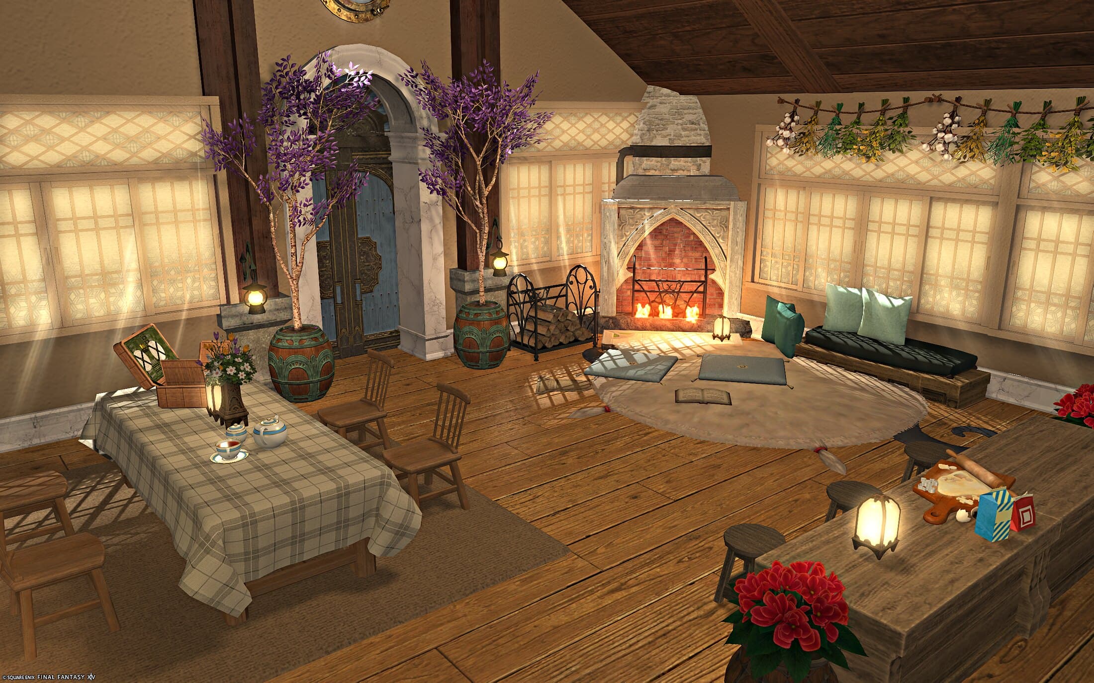 The main floor from the dining side — a plaid-clothed table set with a tea set, the wisteria doorway, and the fireplace and sitting cushions beyond