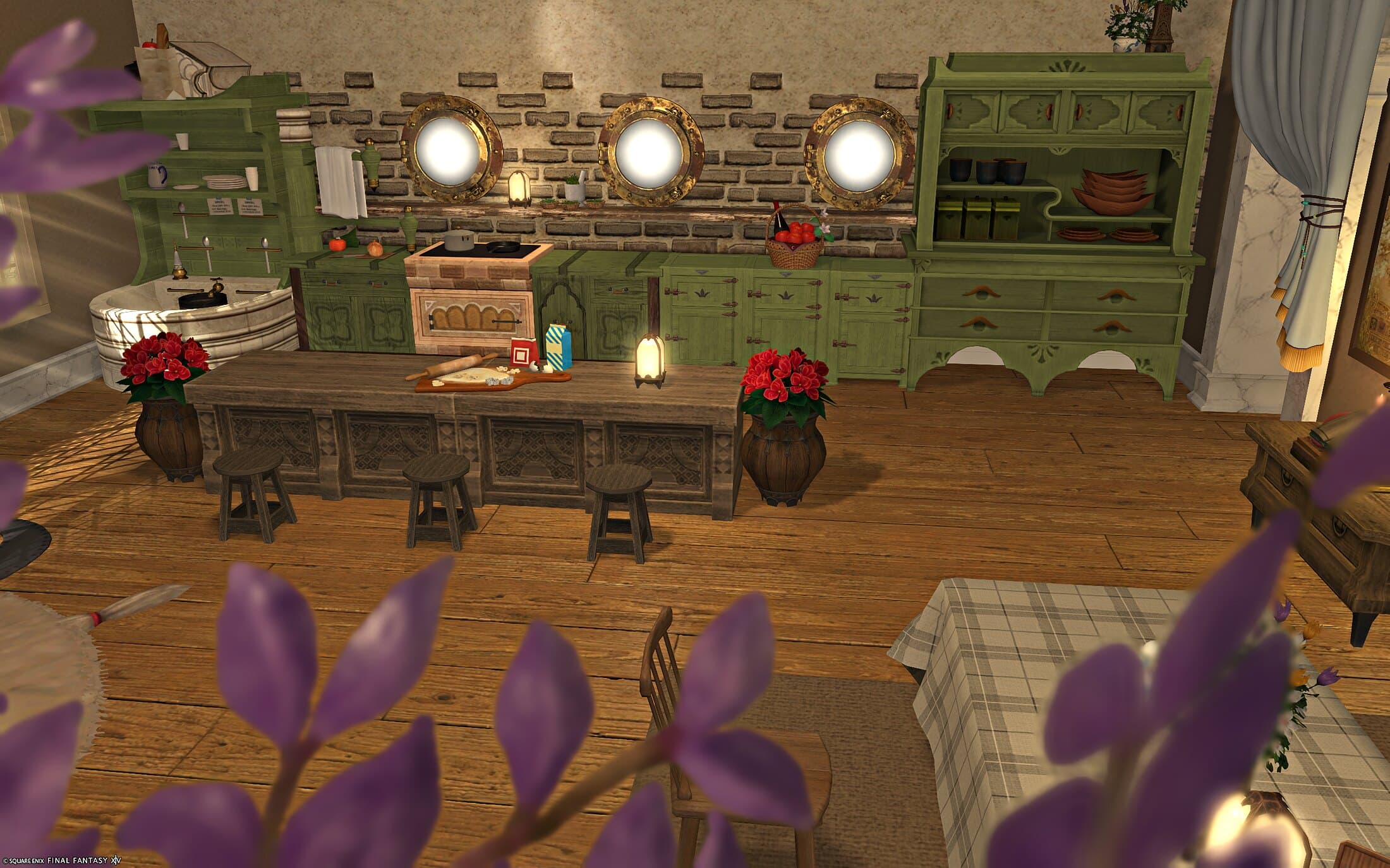 The kitchen counter seen through wisteria blossoms, cookie cutters and a cutting board laid out beside a bowl, the porthole wall and green hutch behind