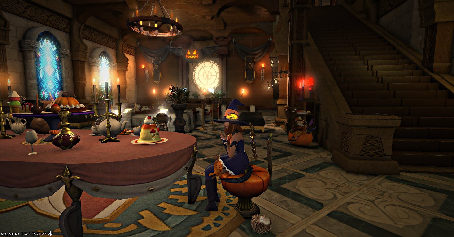 The banquet hall — a long table laid with pumpkins and candles under stained glass, staircase behind